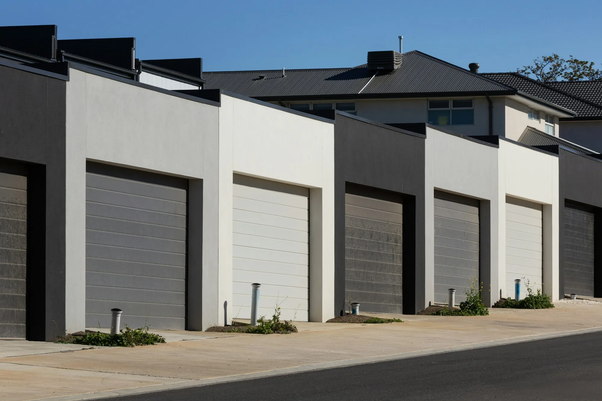 Row of garage doors along a concrete drive